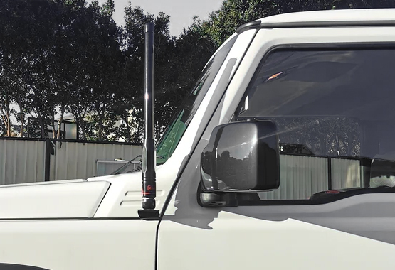 Vehicle-specific UHF bracket fitted neatly beside a 4WD mirror